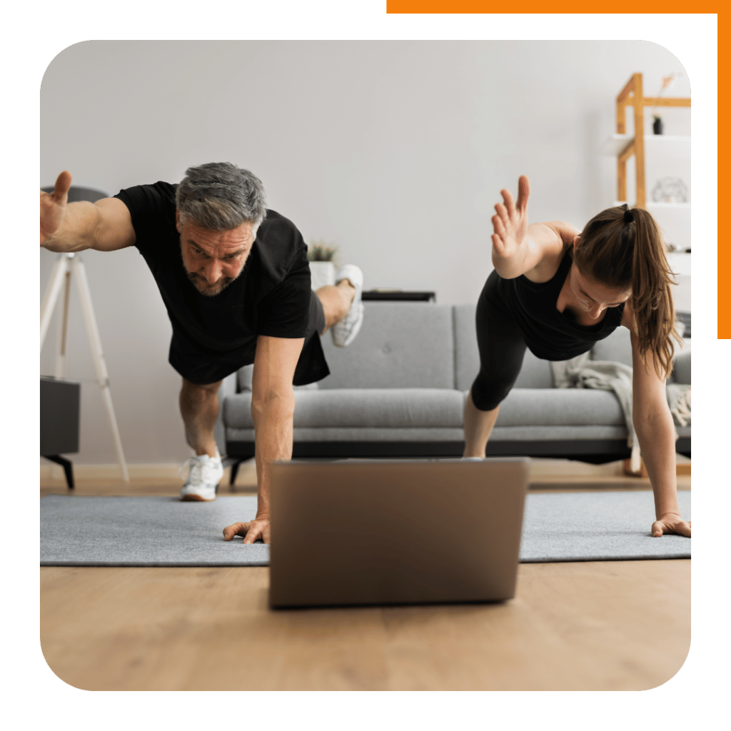 Man and woman doing a home workout following their online personal training plan on a laptop