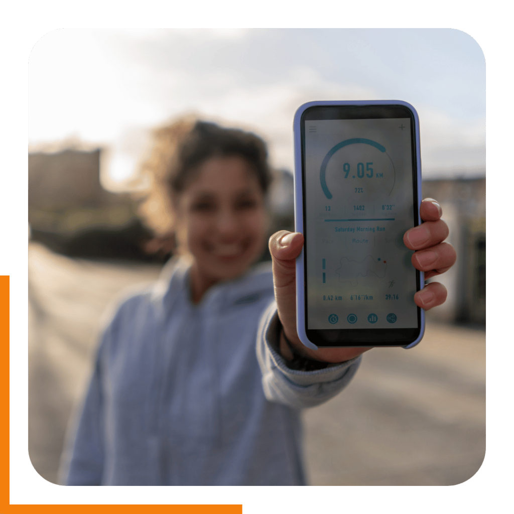Lady holding up her phone with running statistics after a healthy run