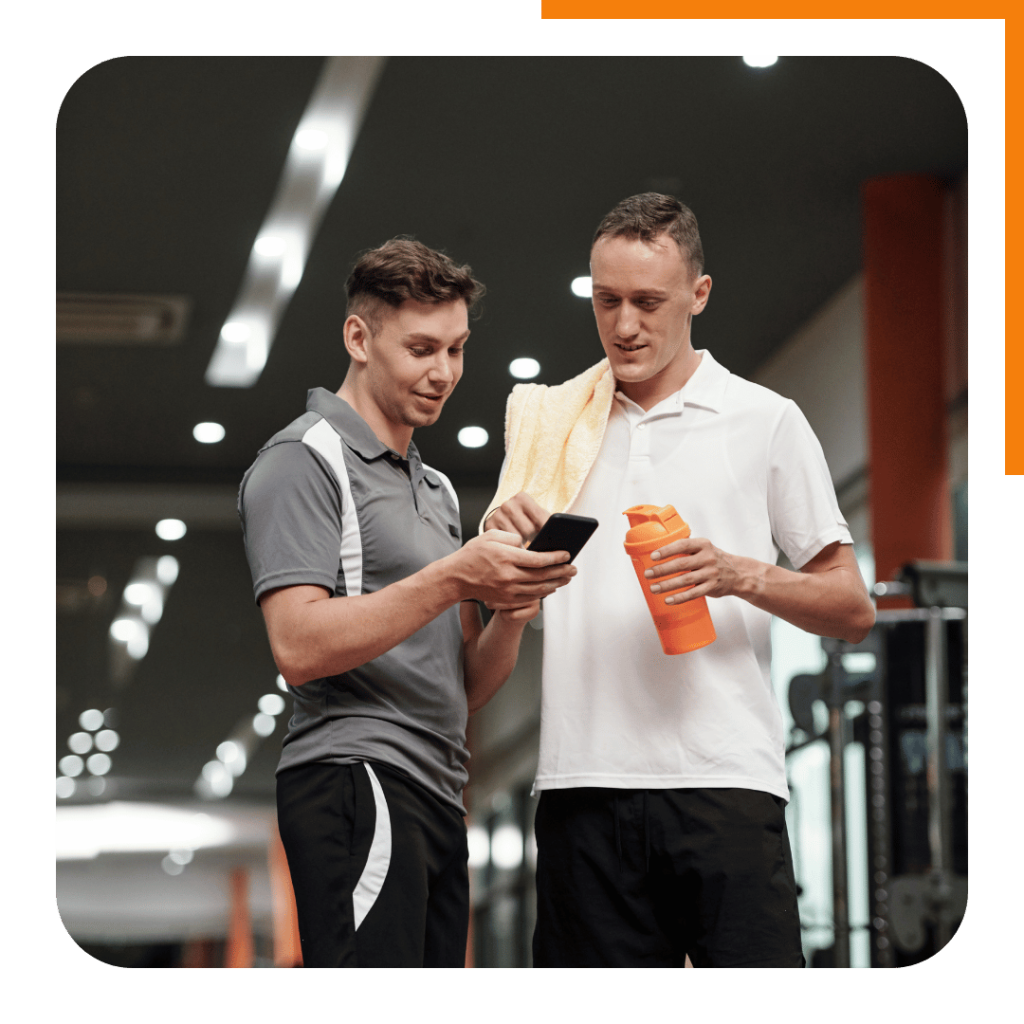 Two men looking at their online personal training program on a phone