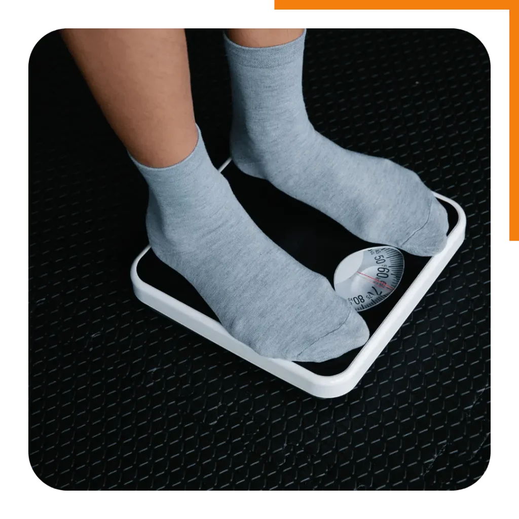 Feet on a bathroom scale, highlighting the importance of tracking weight loss progress over time.