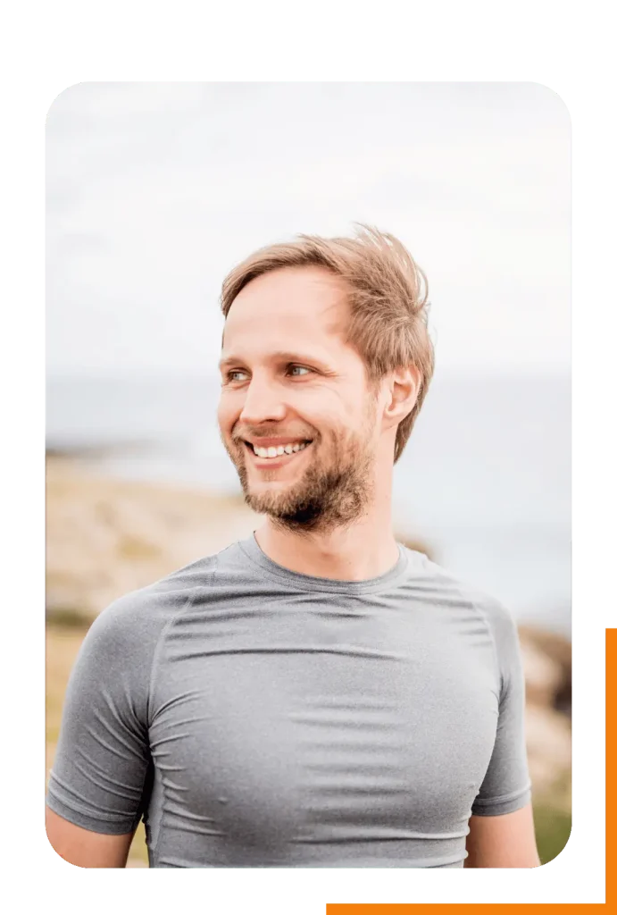 A happy and fit man outside, representing the confidence and vitality that comes from reaching your fitness goals.