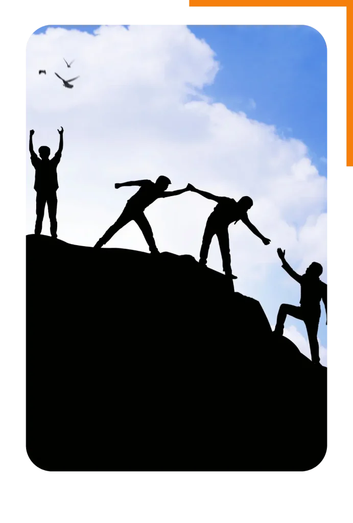 Silhouettes of a group of people helping each other climb a hill, representing the support in goal setting.